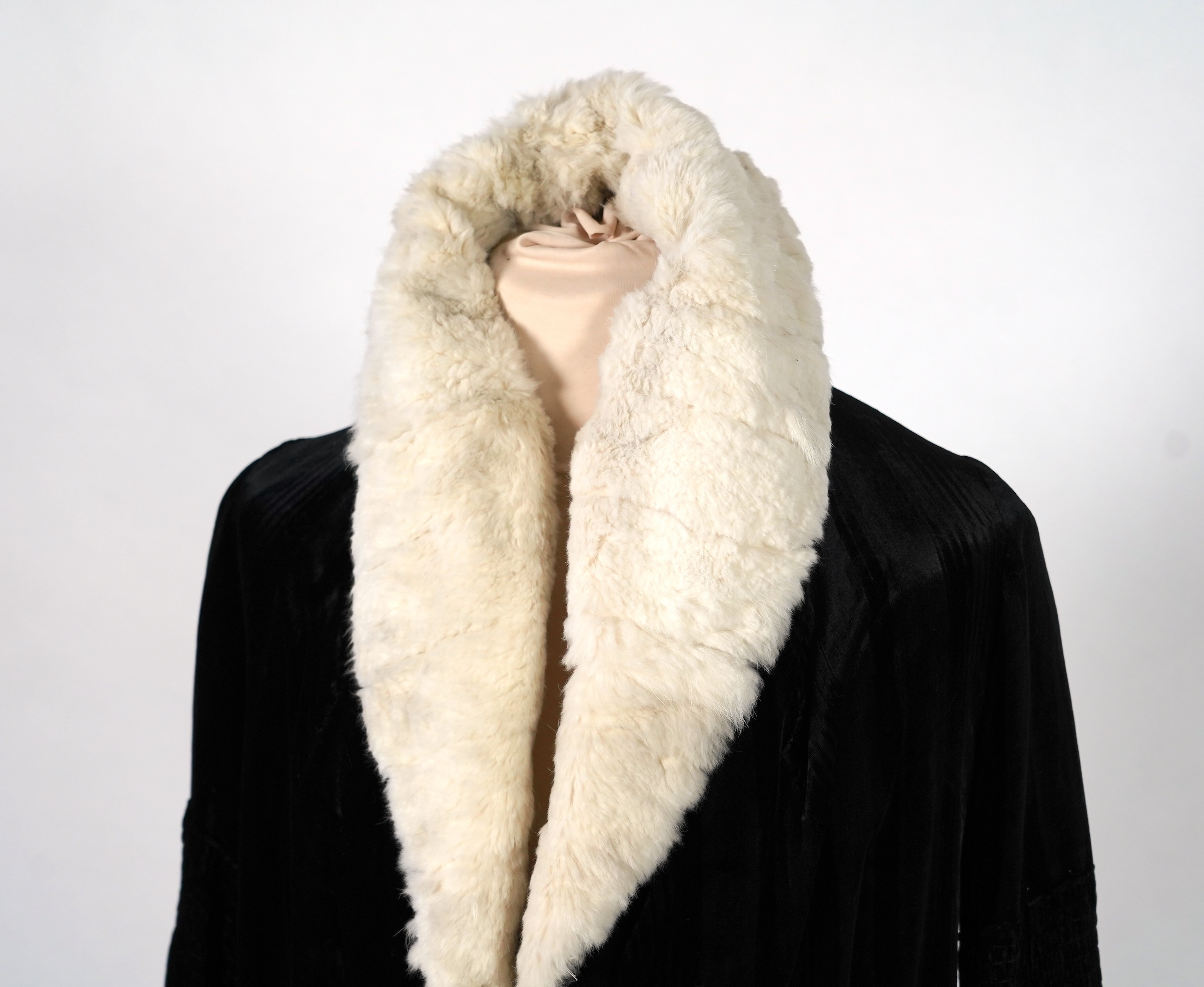 A 1920's ladies black striped silk velvet opera coat with a wide white fur collar and cream satin lining.